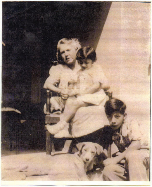 Eva on Grandmother's lap (Dad's Mom) and Uncle Raul playing with dog